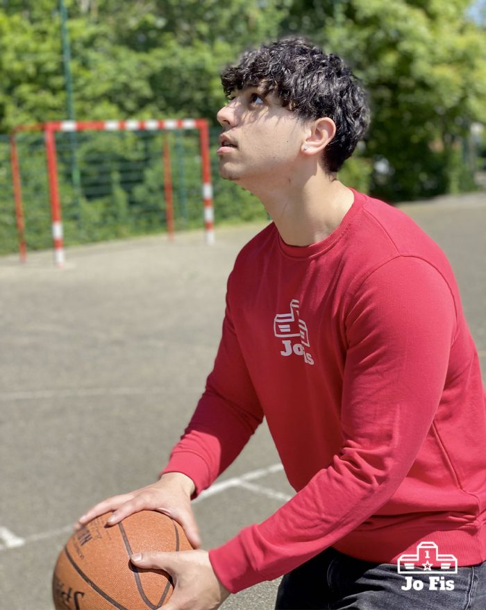 Sweat rouge porté par un homme sur un terrain de basket