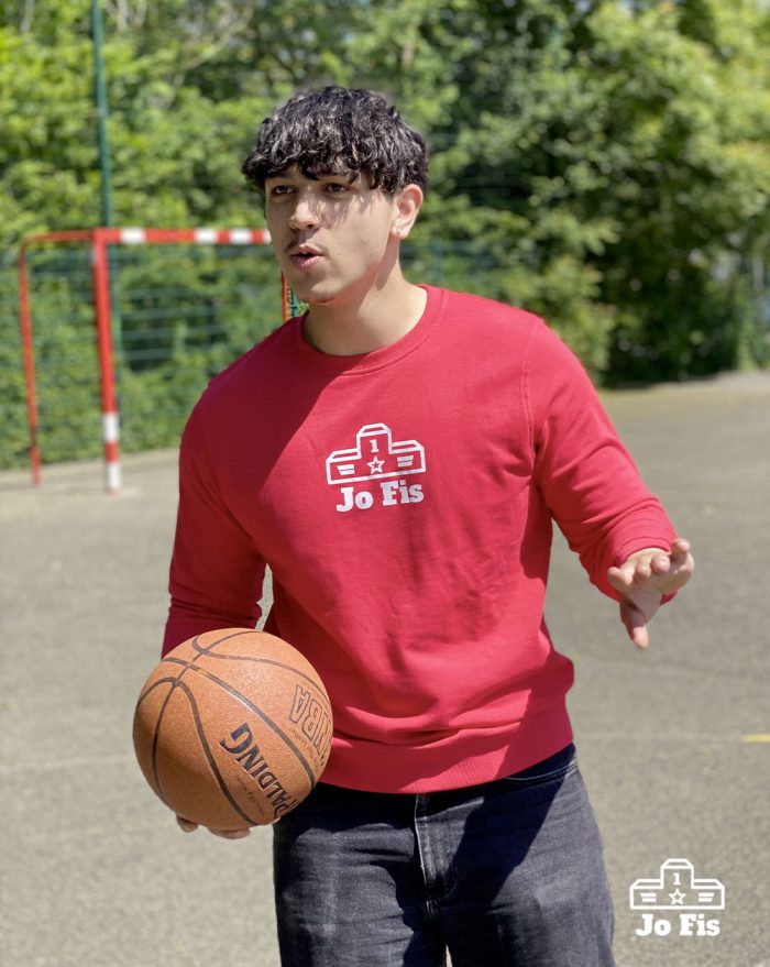 Sweat rouge porté par un homme sur un terrain de basket