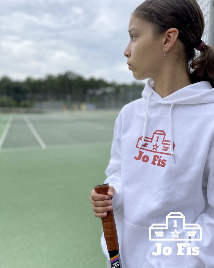 Hoodie blanc porté par une jeune fille sur un terrain de tennis